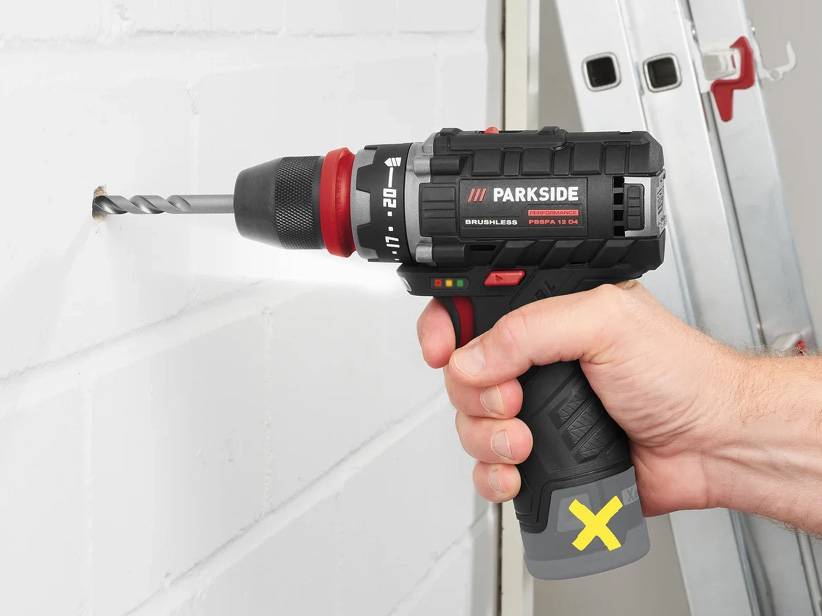Muž používa akumulátorovú vŕtačku Parkside na vŕtanie diery do steny.