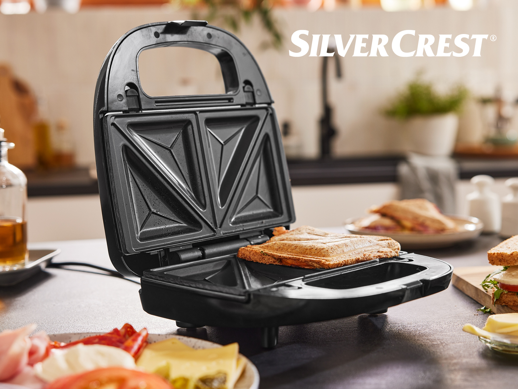 Sendvičovač SilverCrest s pripraveným chlebíčkom na tmavom stole.