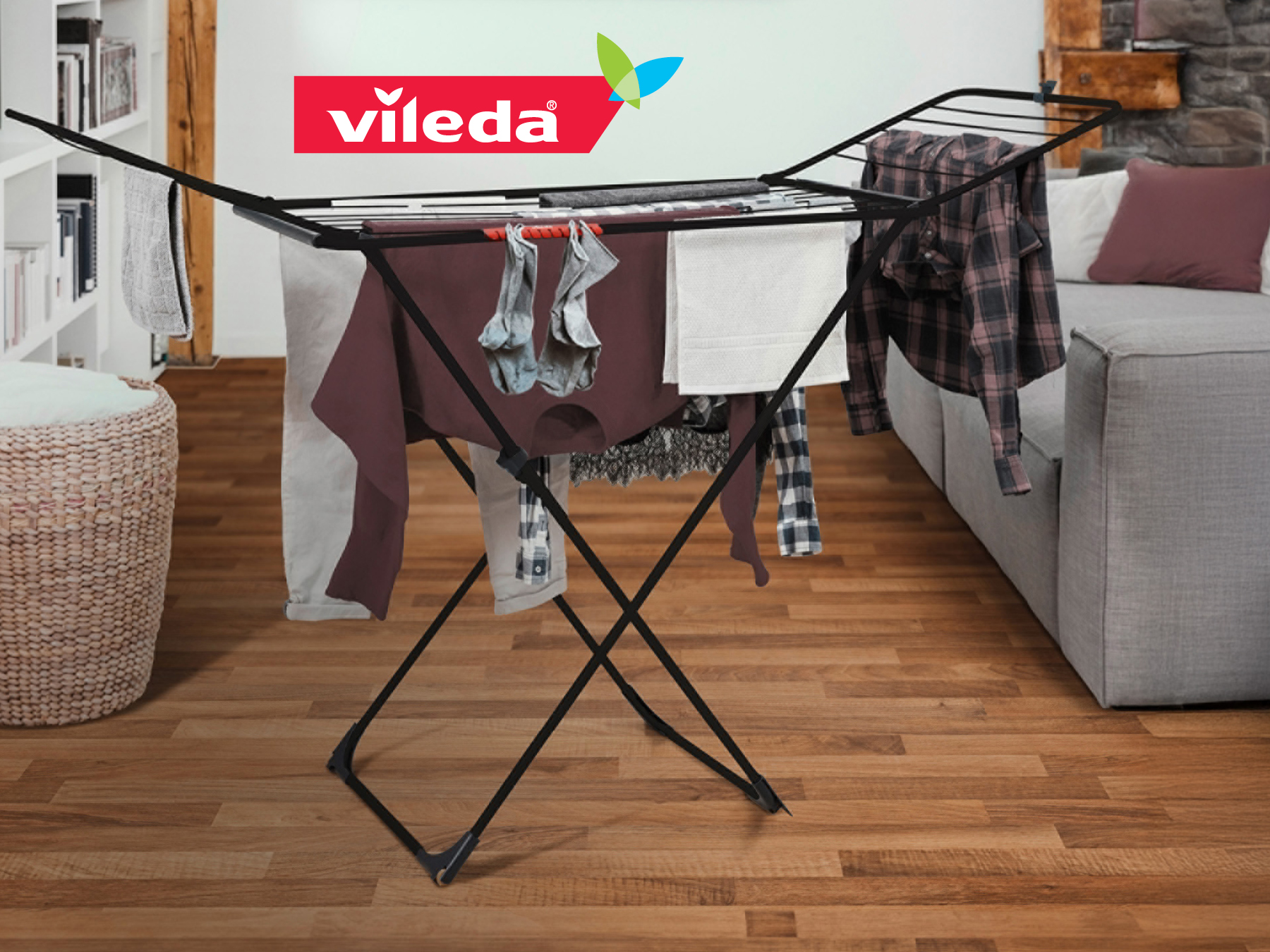Sušiak na prádlo Vileda s oblečením na drevenom podlaží.