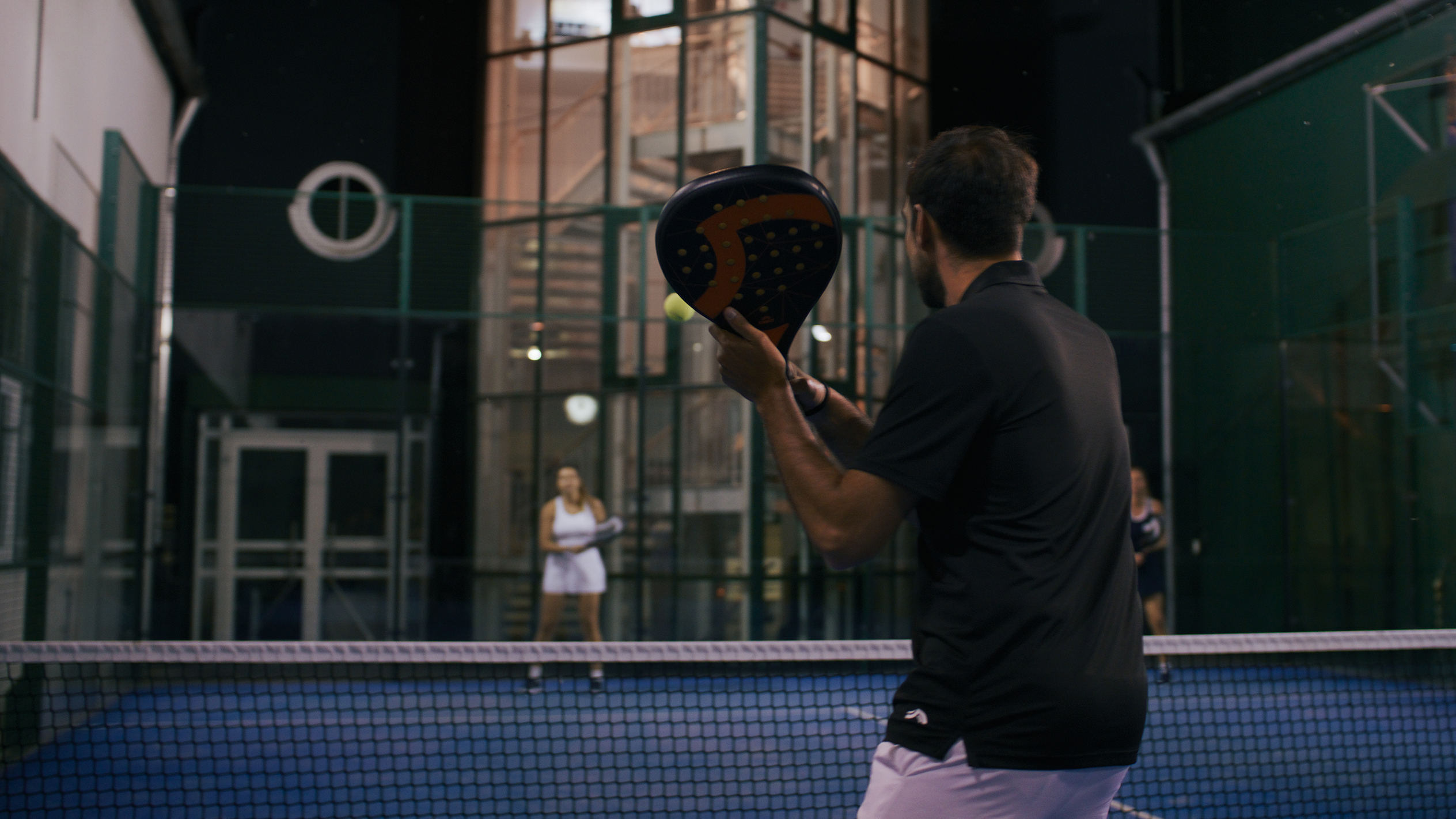 Padeltenis: hráč s raketou, nočný zápas.